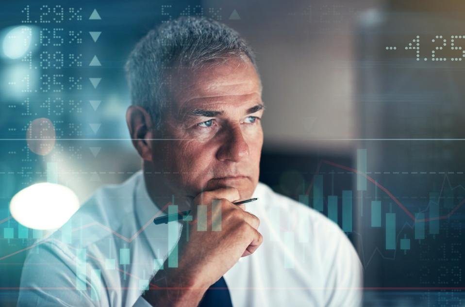 Professional mature businessman in contemplative pose analyzing financial data and market charts overlaid with digital investment graphics